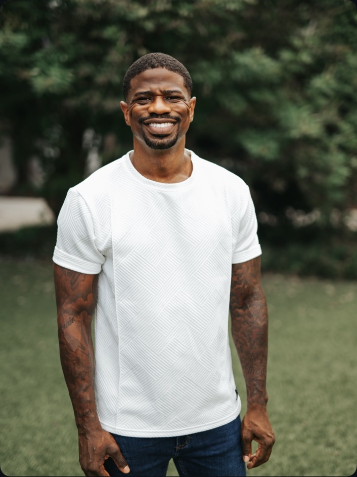 Arion Johnson smiling outdoors in a white shirt